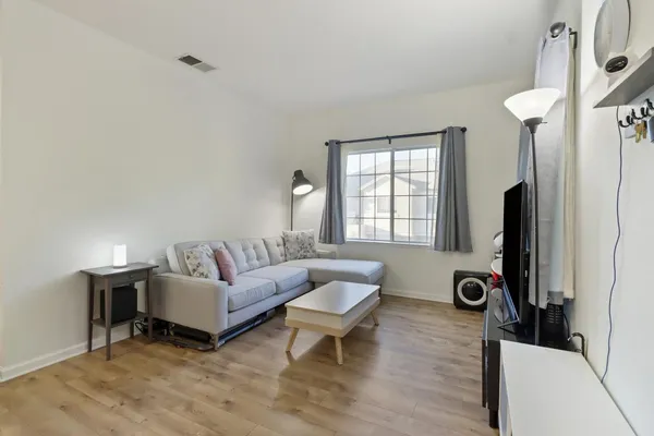 a living room with furniture a window and a flat screen tv