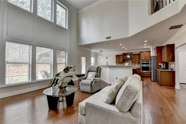 a kitchen with stainless steel appliances granite countertop a refrigerator oven a sink dishwasher and white cabinets with wooden floor