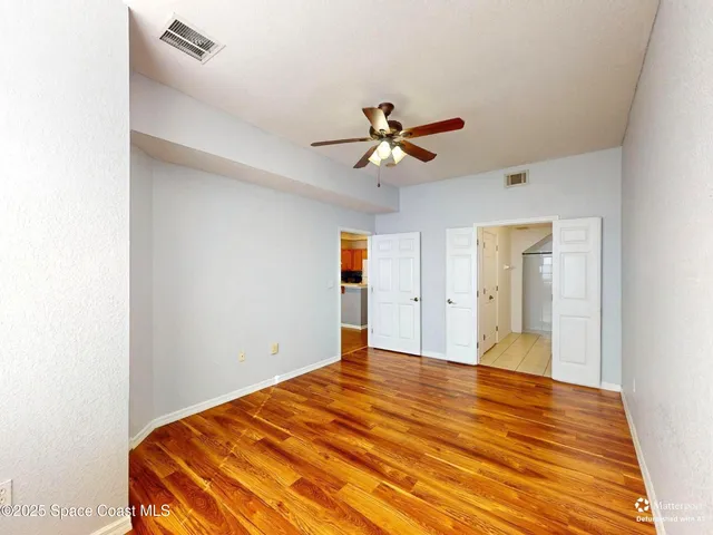 a view of a big room with wooden floor and a ceiling fan