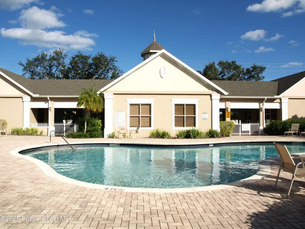 a view of a house with pool fire pit a dining table and chairs with wooden floor