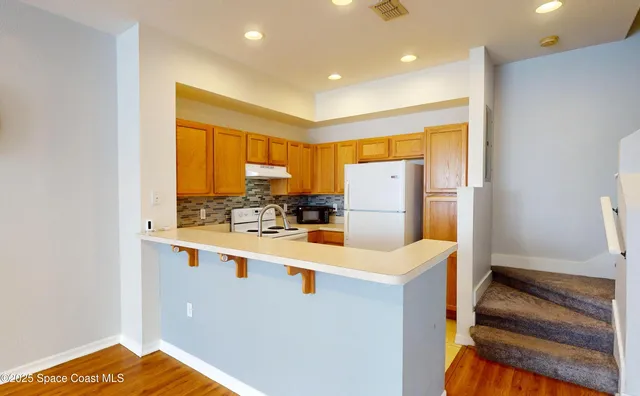 a kitchen with a refrigerator and a stove top oven