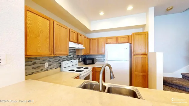 a kitchen with a sink a refrigerator and a stove