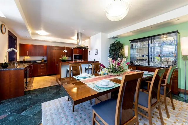 a kitchen with stainless steel appliances kitchen island granite countertop a table chairs in it and wooden floors