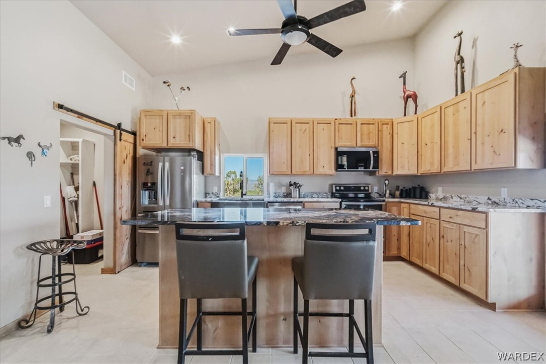 10374 East Happy Trails Road Kingman, AZ 86401 - Photo 15 of 68 a kitchen with stainless steel appliances granite countertop a sink stove and refrigerator