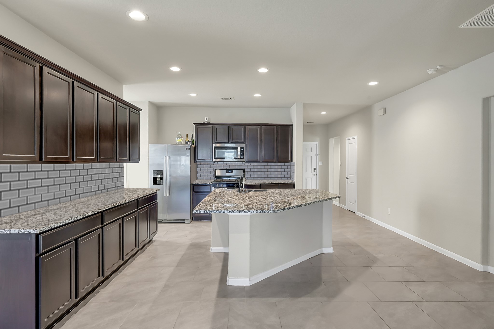 3310 Scout Island Katy, TX 77494 - Photo 7 of 42 a large kitchen with stainless steel appliances kitchen island granite countertop a large counter top a stove and a sink