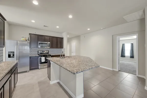 a kitchen with stainless steel appliances granite countertop a sink stove and refrigerator