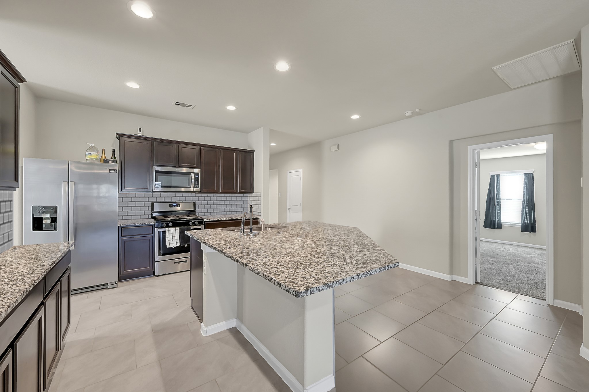 3310 Scout Island Katy, TX 77494 - Photo 8 of 42 a kitchen with stainless steel appliances granite countertop a sink stove and refrigerator