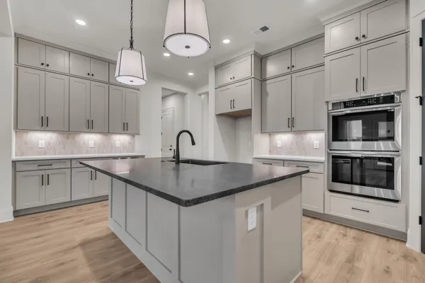 a kitchen with granite countertop white cabinets and stainless steel appliances