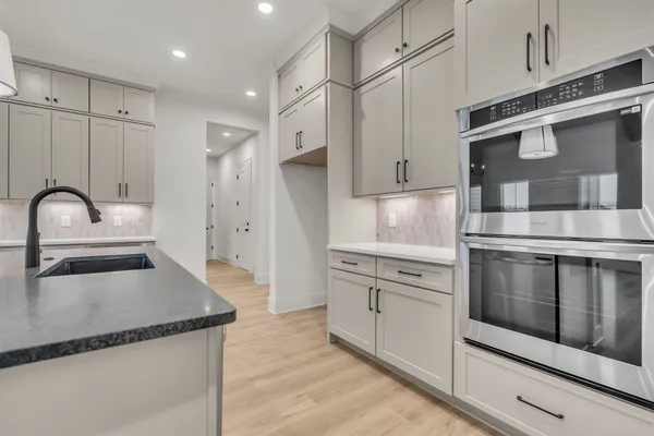 a view of a kitchen with a sink dishwasher a refrigerator and a chandelier
