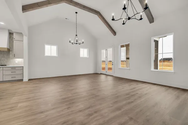a view of empty room with wooden floor and window