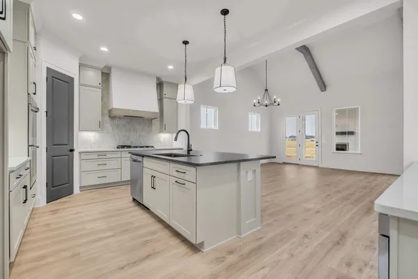 a kitchen with cabinets stainless steel appliances and sink
