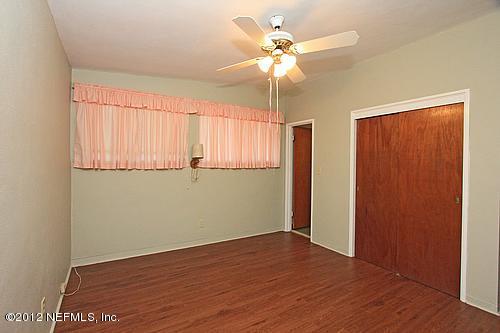 3045 Kline Road Jacksonville, FL 32246 - Photo 7 of 15 an empty room with wooden floor fan and windows