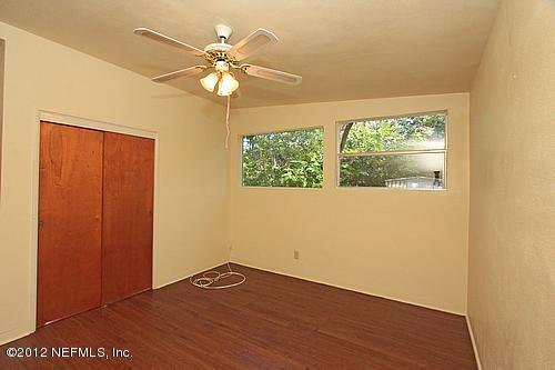 3045 Kline Road Jacksonville, FL 32246 - Photo 9 of 15 an empty room with wooden floor fan and windows