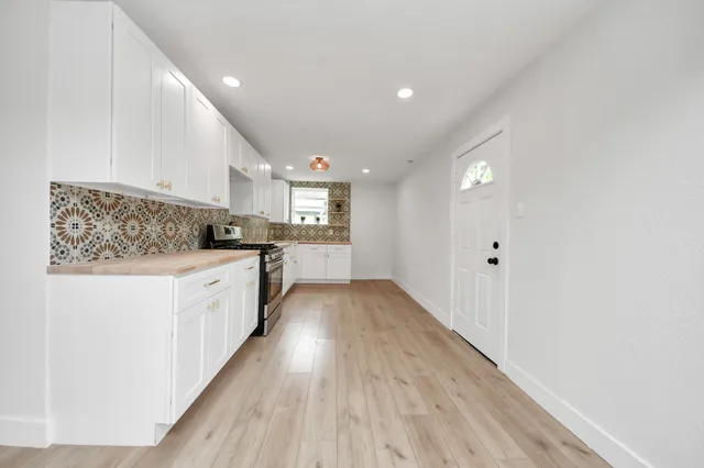 a kitchen with cabinets and wooden floor