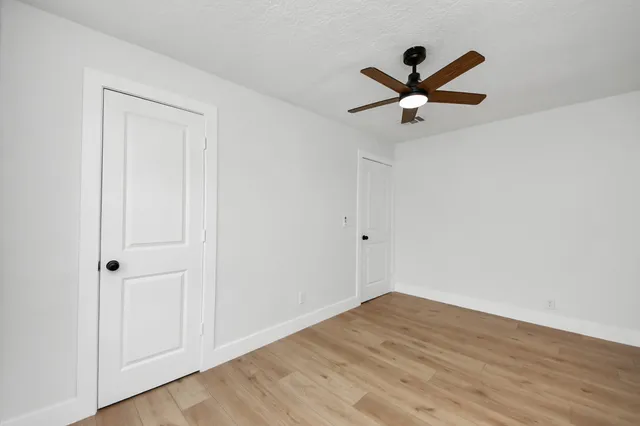 a view of empty room with wooden floor