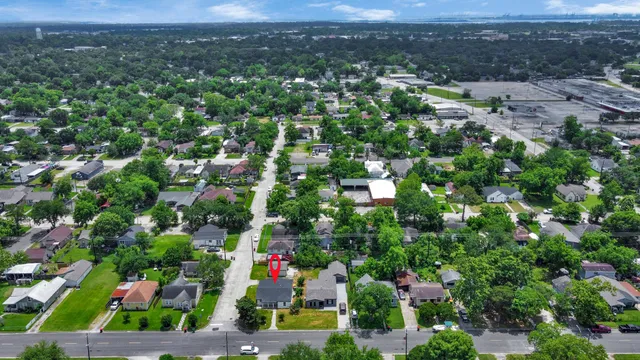 an aerial view of residential houses with outdoor space and trees