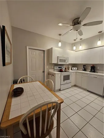 a kitchen with a sink a stove and chairs