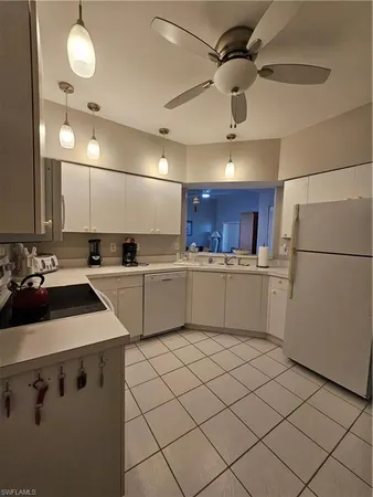 a kitchen with cabinets a sink and white appliances