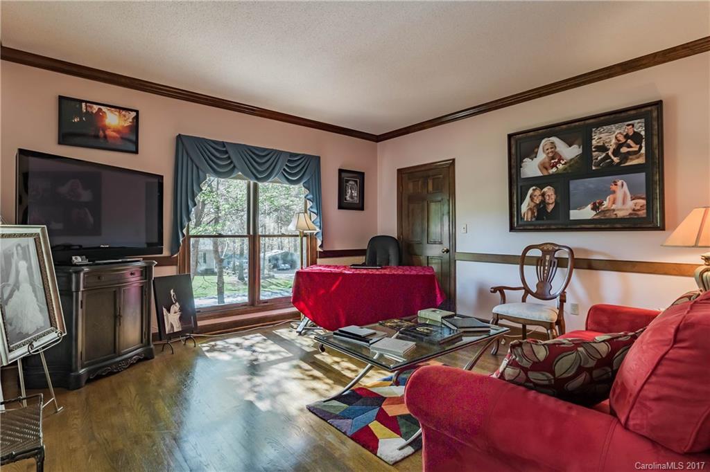 1697 Double Oaks Road Fort Mill, SC 29715 - Photo 5 of 24 a living room with furniture a flat screen tv and a floor to ceiling window