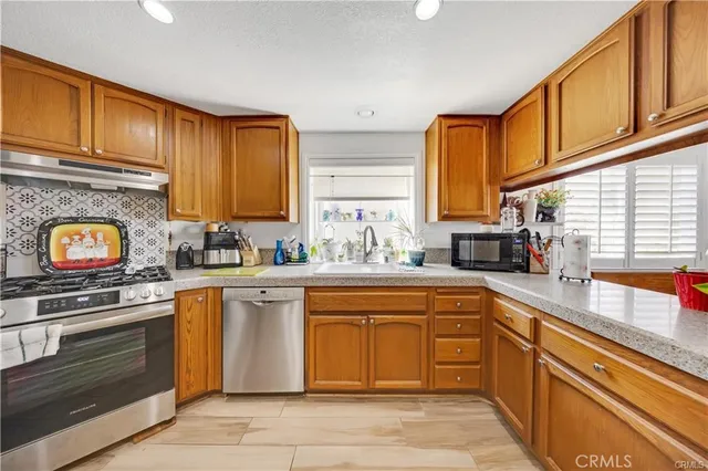 a kitchen with stainless steel appliances granite countertop a stove sink and cabinets