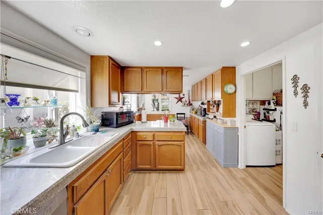 a kitchen with kitchen island granite countertop a sink cabinets and stainless steel appliances
