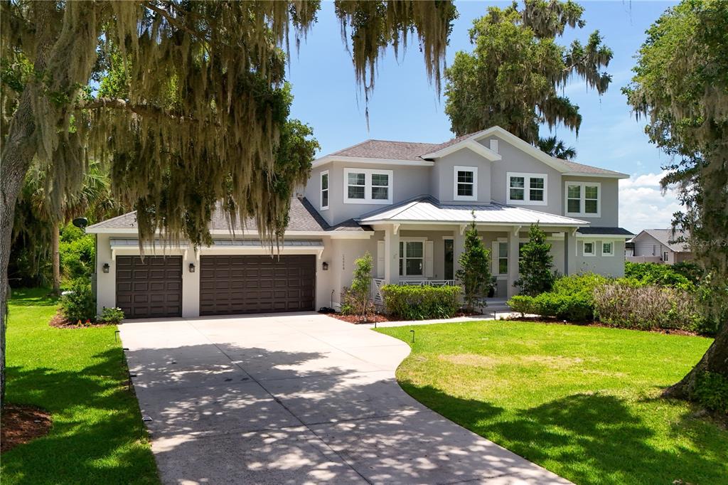 16948 Deer Island Road Tavares, FL 32778 - Photo 2 of 67 a front view of a house with a yard and garage