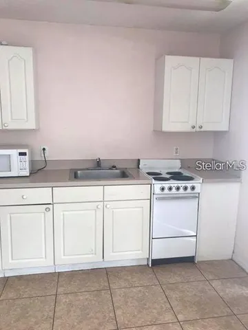 a kitchen with white cabinets and white appliances