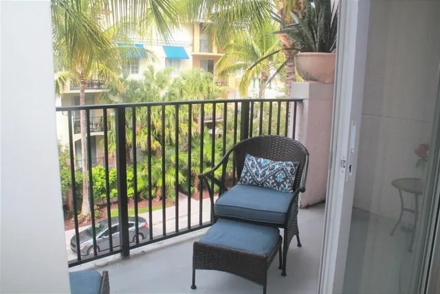 a balcony with couch and a potted plant
