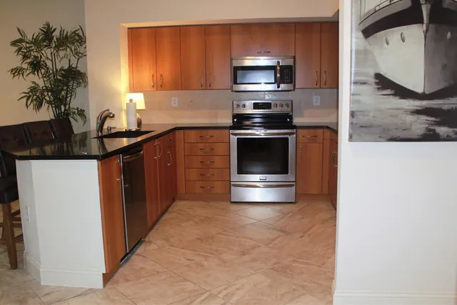 a kitchen with stainless steel appliances a stove microwave and sink