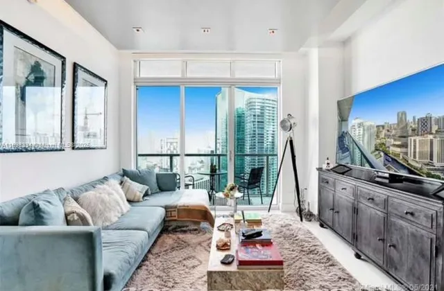a living room with furniture a large window and a flat screen tv