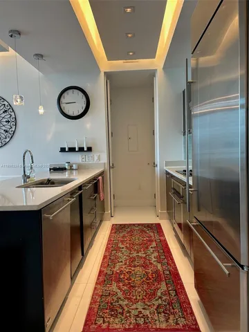 a large kitchen with a sink and stainless steel appliances