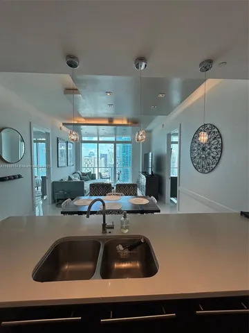 a kitchen with a sink and a stove with white countertops