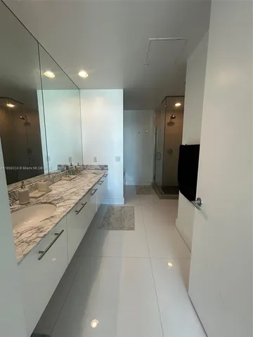 a bathroom with a granite countertop sink a toilet and a large mirror