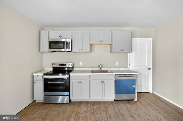 a kitchen with stainless steel appliances granite countertop a stove a sink and a microwave