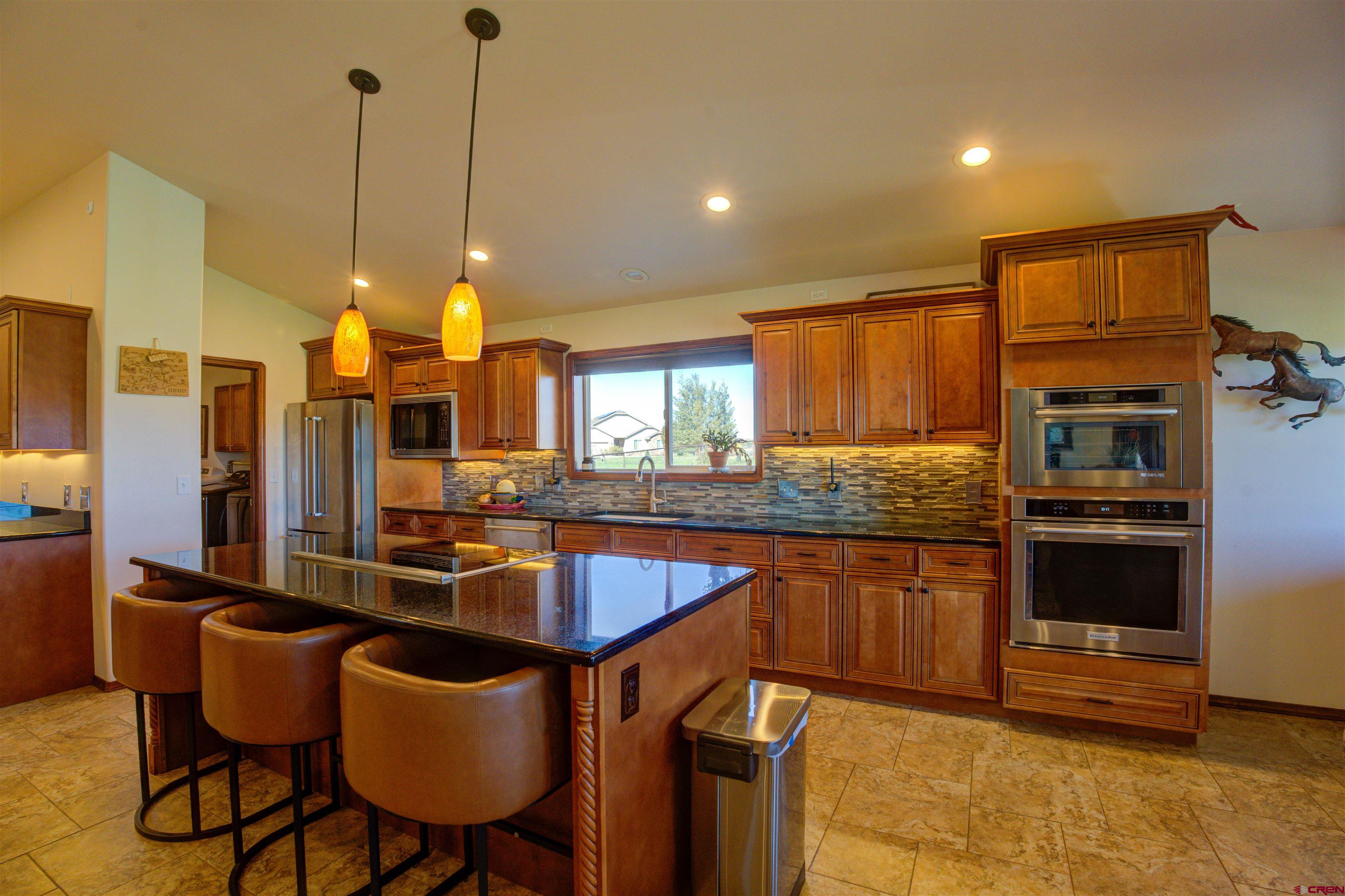 12336 Road 23.25 Loop Cortez, CO 81321 - Photo 12 of 43 a kitchen with stainless steel appliances granite countertop a sink a stove and a refrigerator