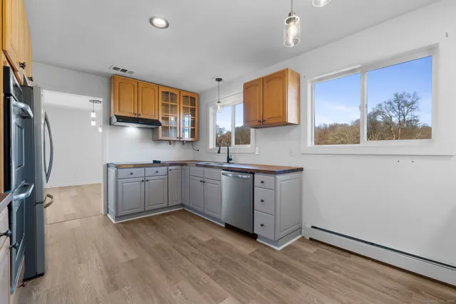 a kitchen with stainless steel appliances a sink cabinets and wooden floor