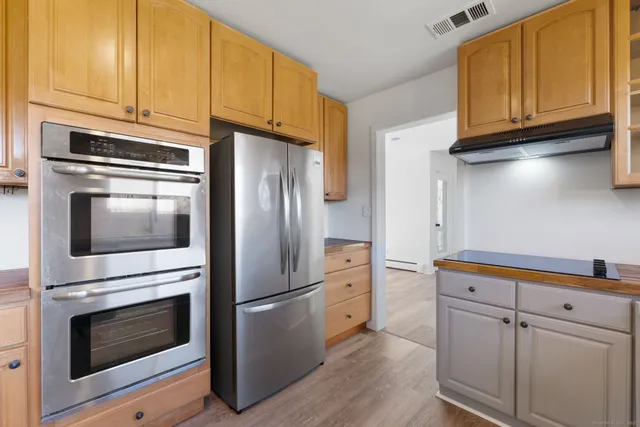 a kitchen with stainless steel appliances granite countertop a refrigerator stove and cabinets