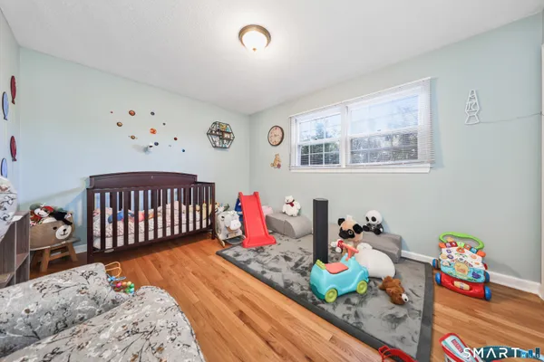 a bedroom with bed and wooden floor