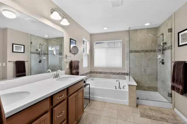 a spacious bathroom with a tub sink shower and mirror