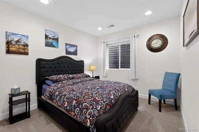 a bedroom with a bed a wall painting and a window