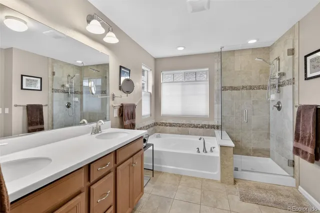 a spacious bathroom with a tub sink shower and mirror