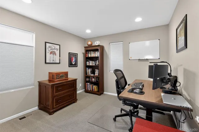 a view of a workspace with furniture and a window