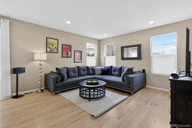 a living room with furniture and a wooden floor