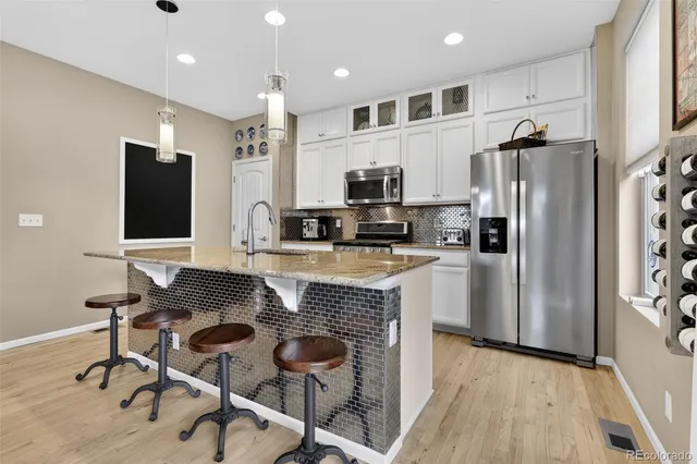 a kitchen with stainless steel appliances granite countertop a stove a sink a refrigerator and a microwave