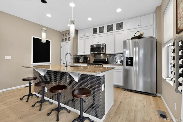 a kitchen with a refrigerator and a stove top oven
