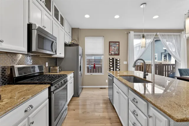 a kitchen with stainless steel appliances granite countertop a stove a sink and a microwave
