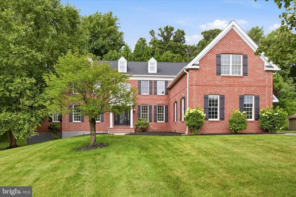 a front view of a house with a yard and trees