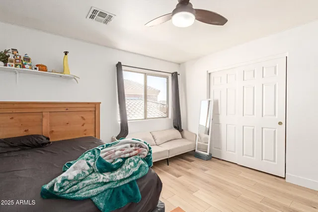 a bedroom with a bed and a large mirror with a hardwood