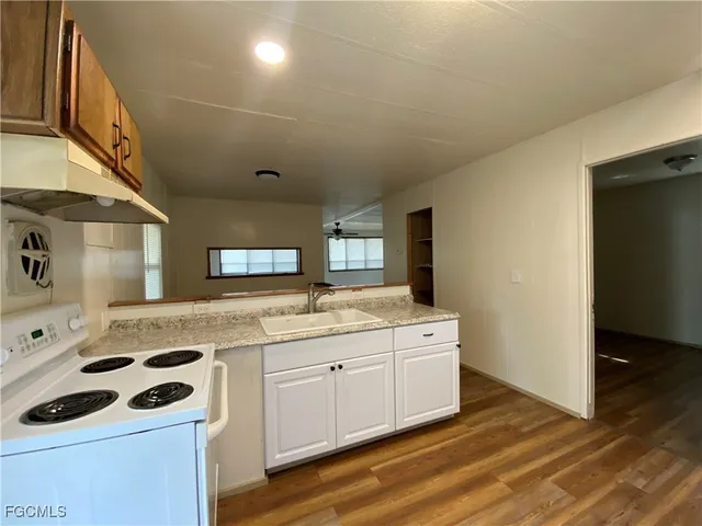 a kitchen with a sink a stove and cabinets
