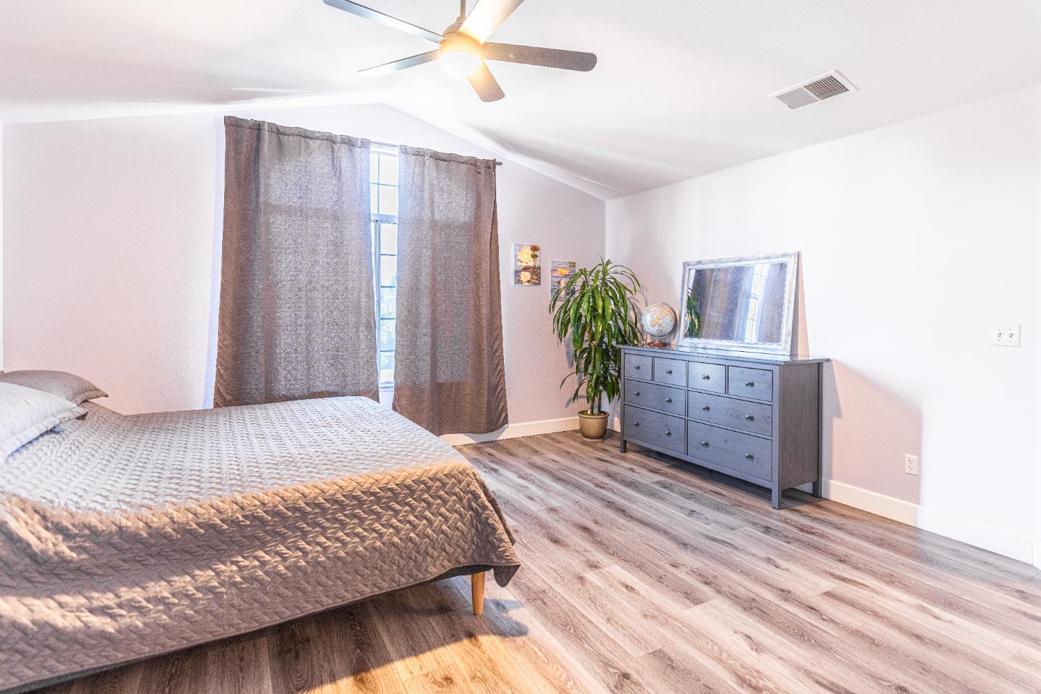 2322 East Revere Road Fresno, CA 93720 - Photo 20 of 33 a bedroom with a bed and a chandelier